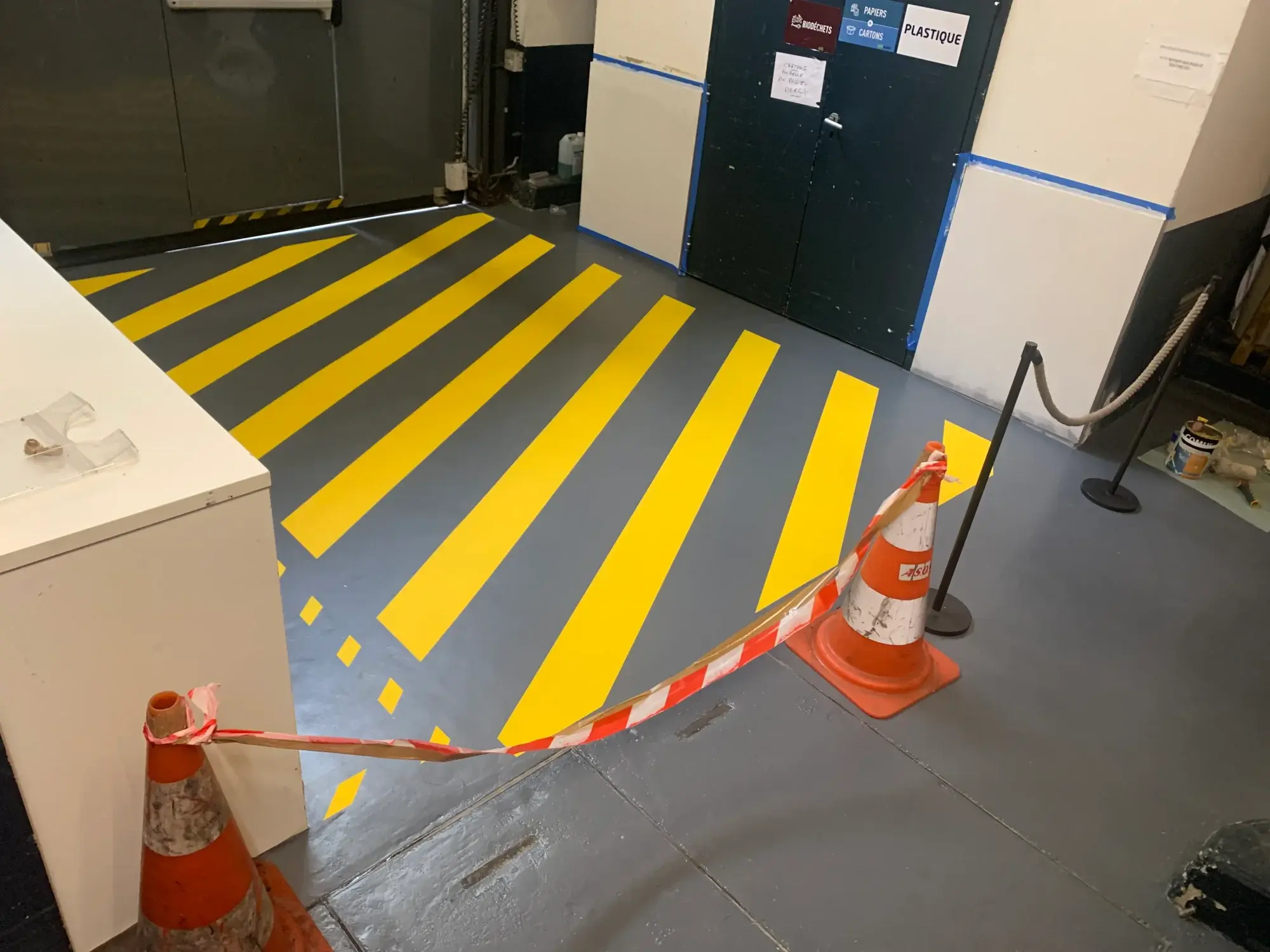 Entrepôt avec sol en résine polyuréthane grise et marquages jaunes de circulation